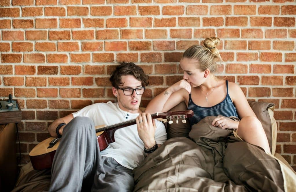 A man using guitar and a woman watching him