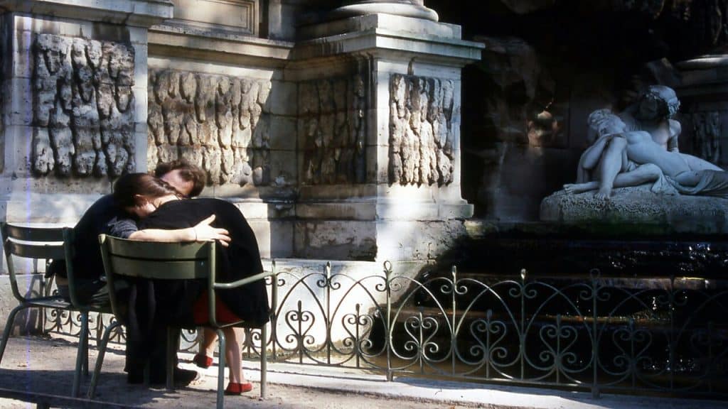 A man and a woman hugging on a bench