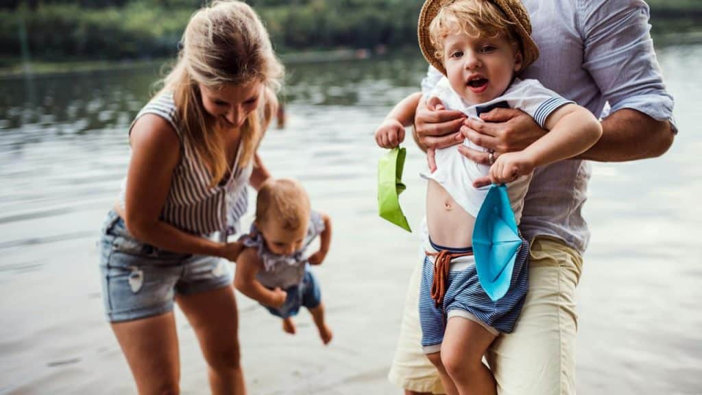 A family playing with their children by a lakeside.