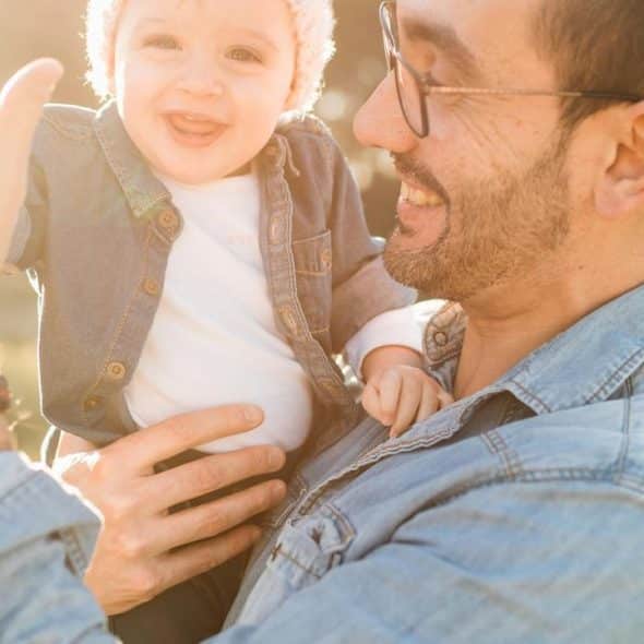 A man holding a smiling baby.