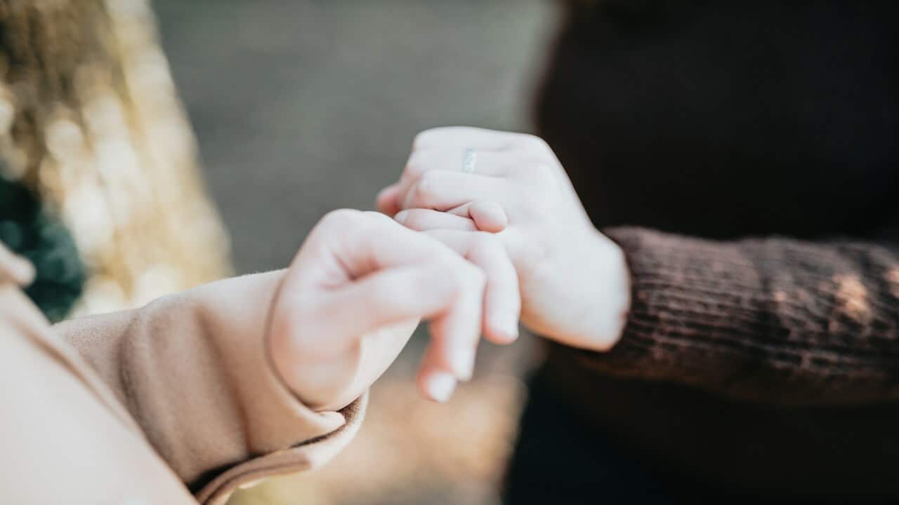 Two people doing the pinky promise.