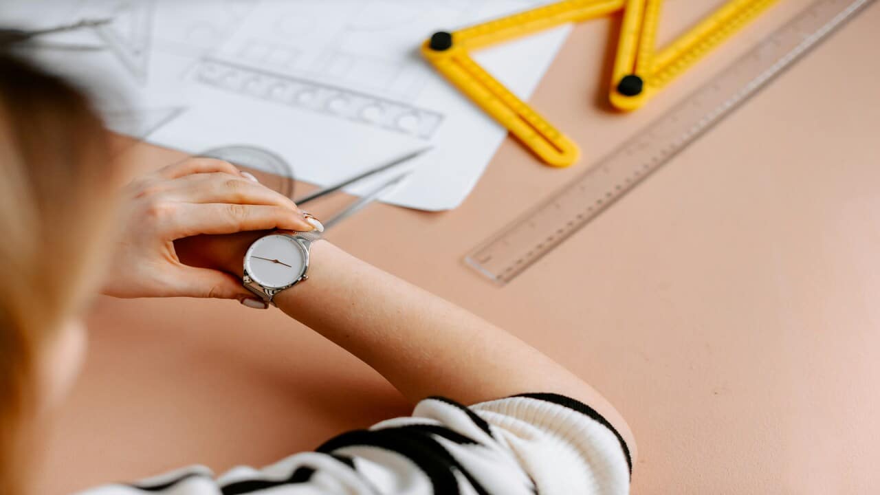 A woman looking at her wrist watch.