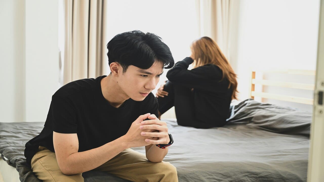 A couple ignoring each other in the bedroom.