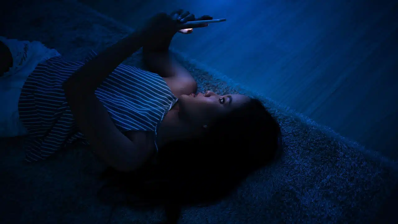 A woman texting at night.