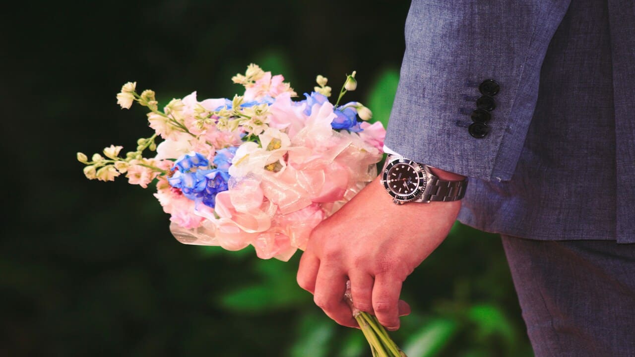 A man holding a bouquet of flowers.