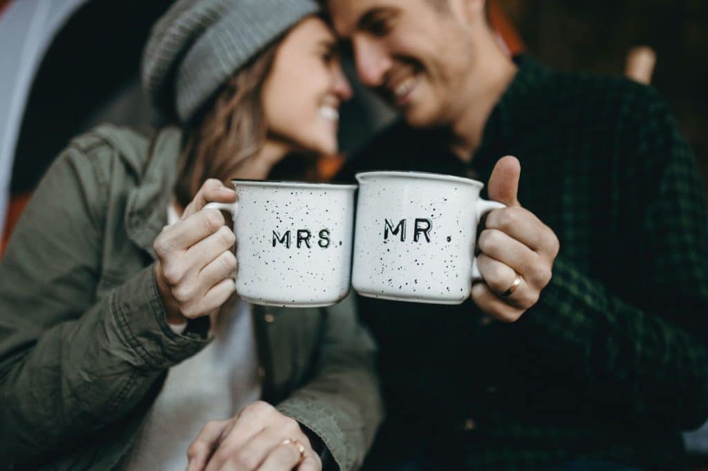 A married couple holding a cup 