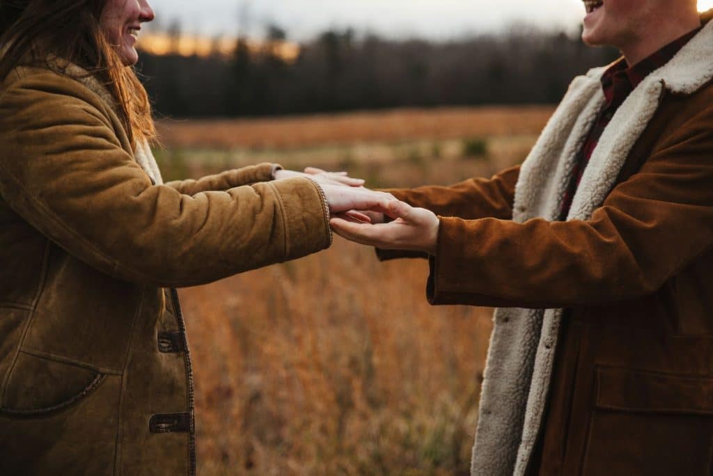 A man and woman holding hands and facing each other 