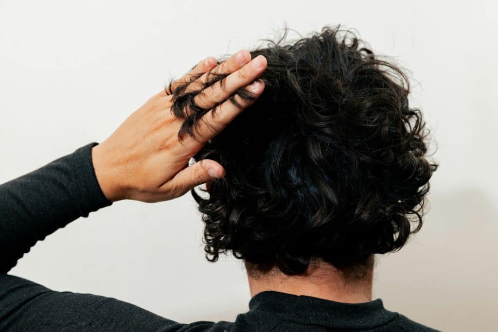A man touching his hair