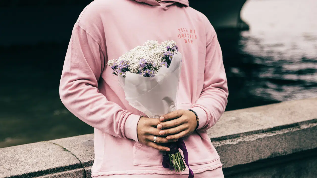 A man holding a bouquet of flowers.