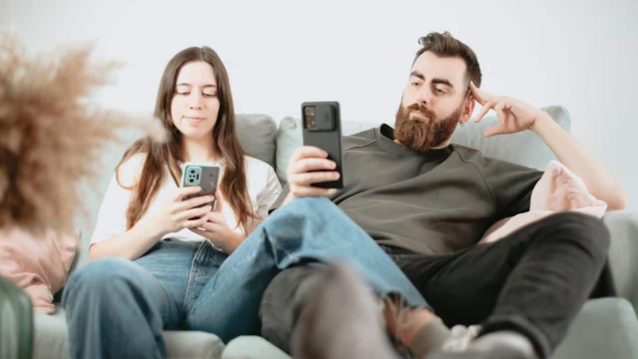 Man emotionally disengaged while partner sits beside him.