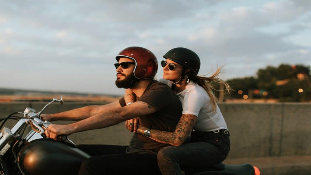 A couple riding a motorcycle.