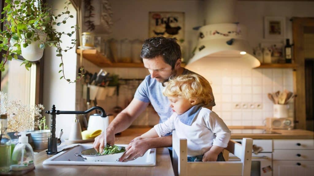 A man watching vegetables with his son.