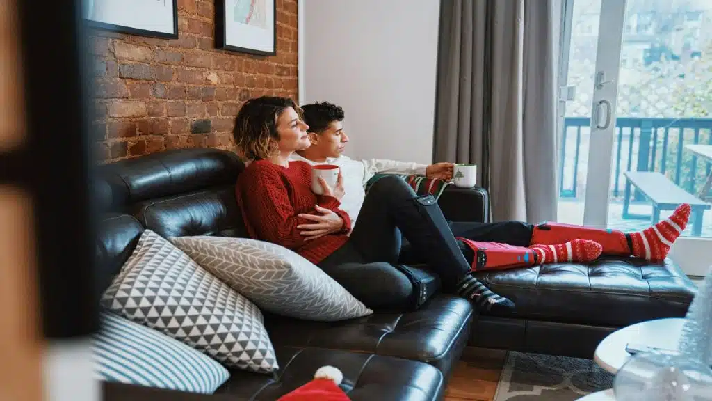 A couple sitting close together at home.