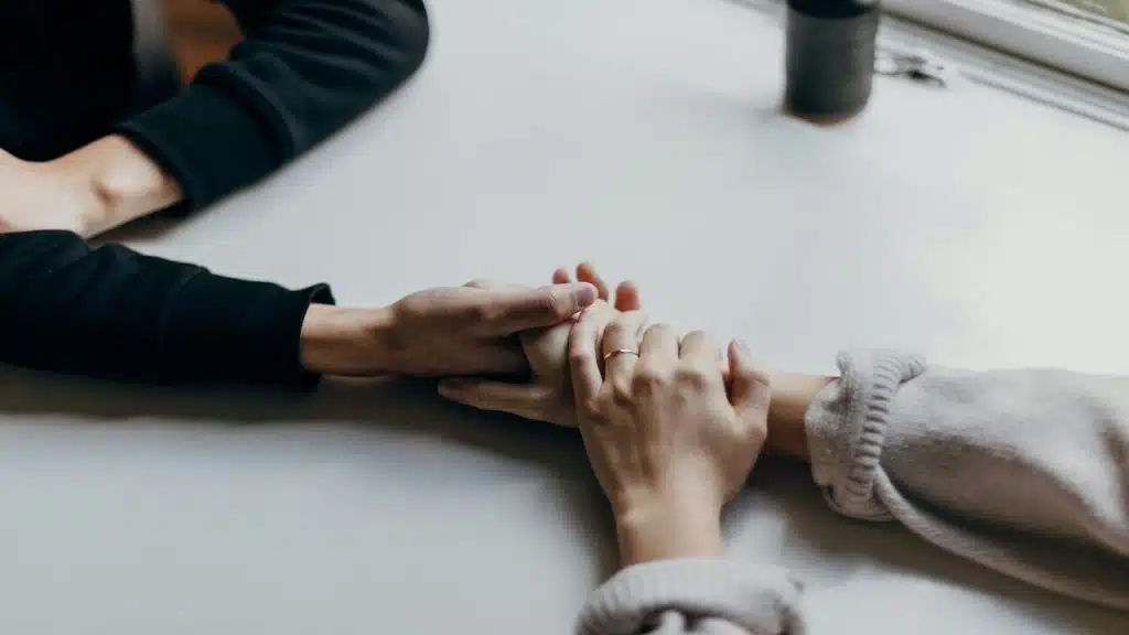 A couple holding hands at a cafe.
