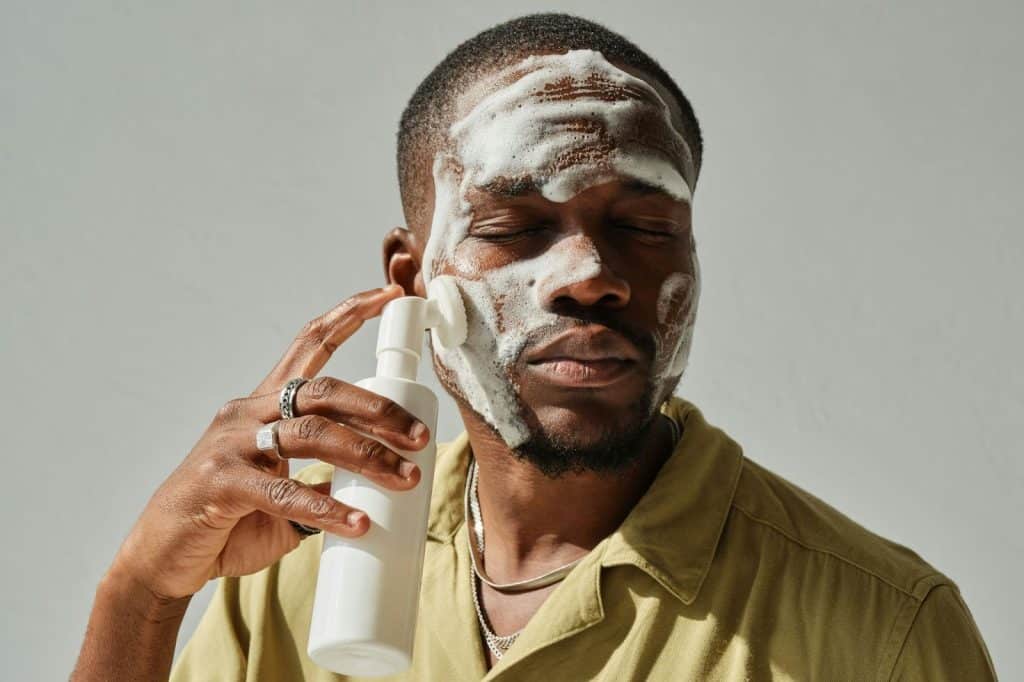 A man using a facial cleanser