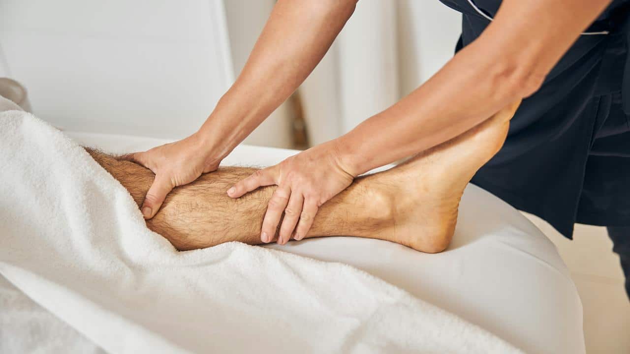 A person receiving a lower leg massage from a massage therapist.
