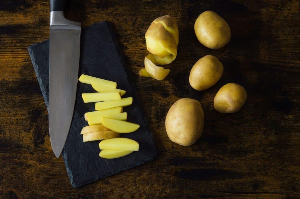A set of sliced potatoes with a knife.