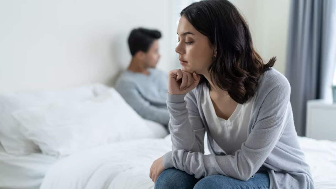 ALT Text: Man noticing emotional tension even during quiet relationship moments.