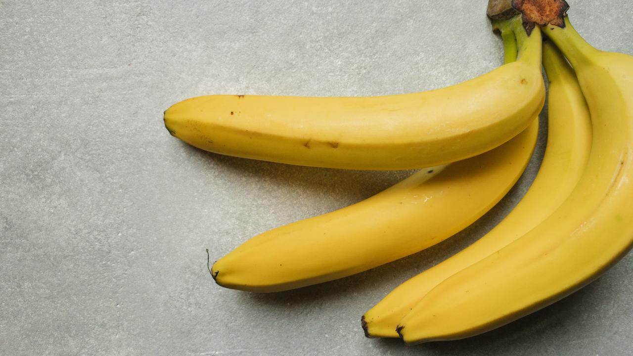 A bunch of bananas on a gray surface.
