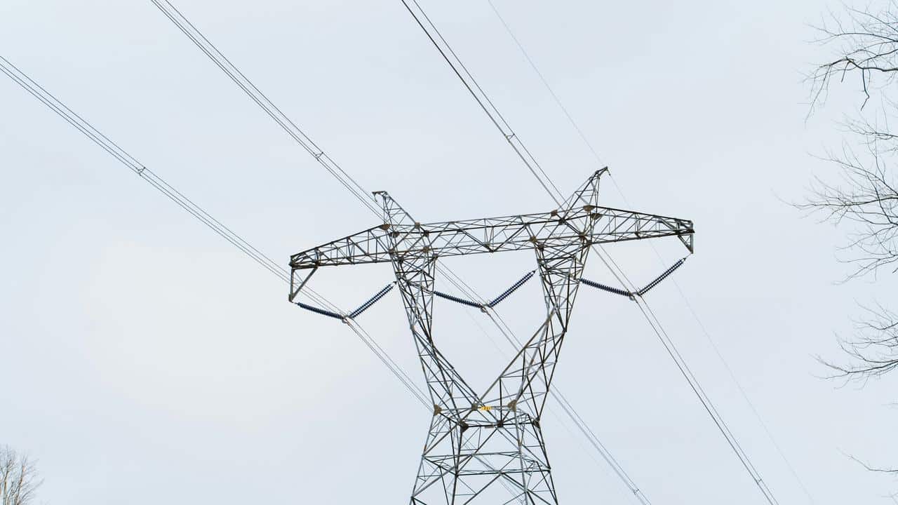 A power line tower against the sky.