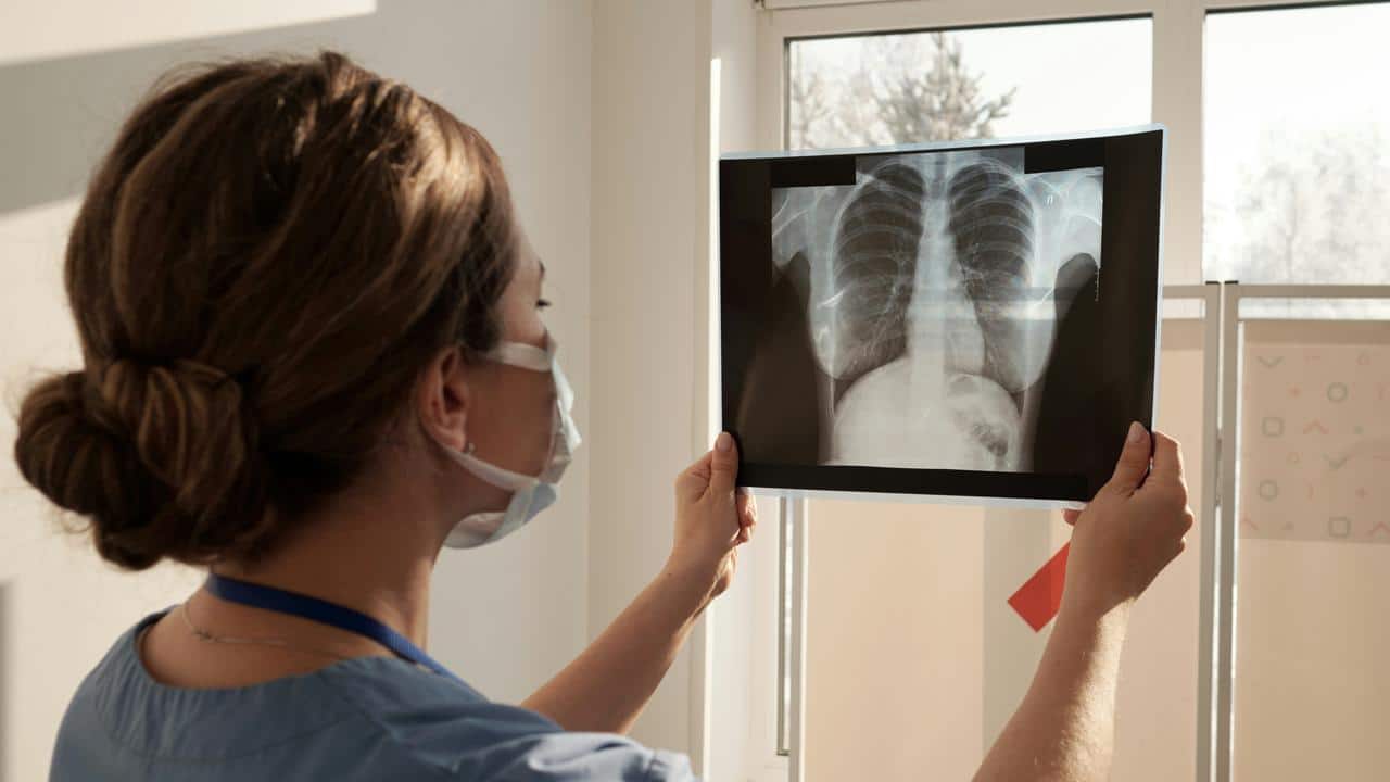 A medical professional examining a chest X-ray.