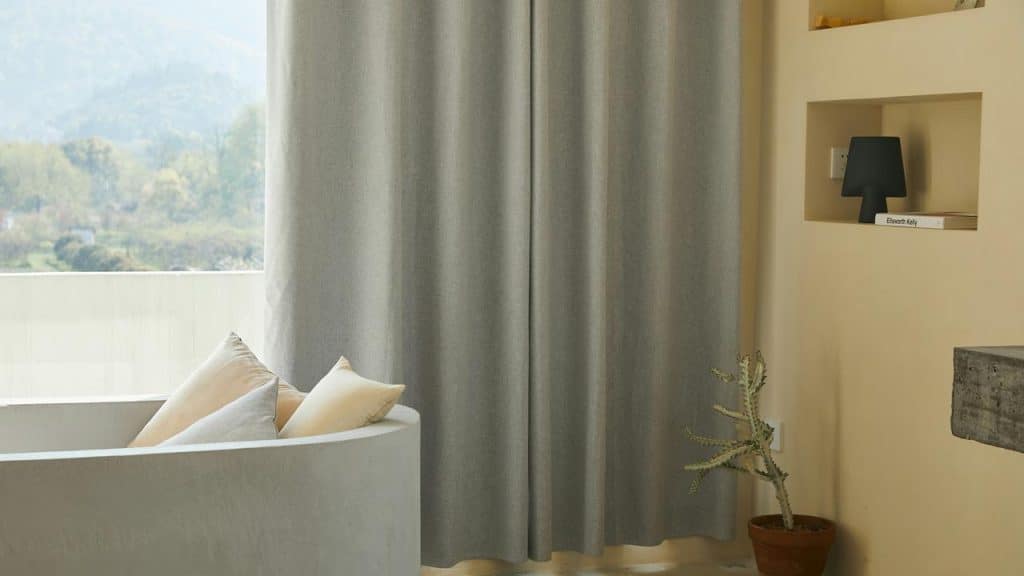 A photo of gray hotel curtains next to a sofa.