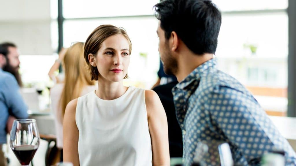 A woman listening attentively to a man in a restaurant.