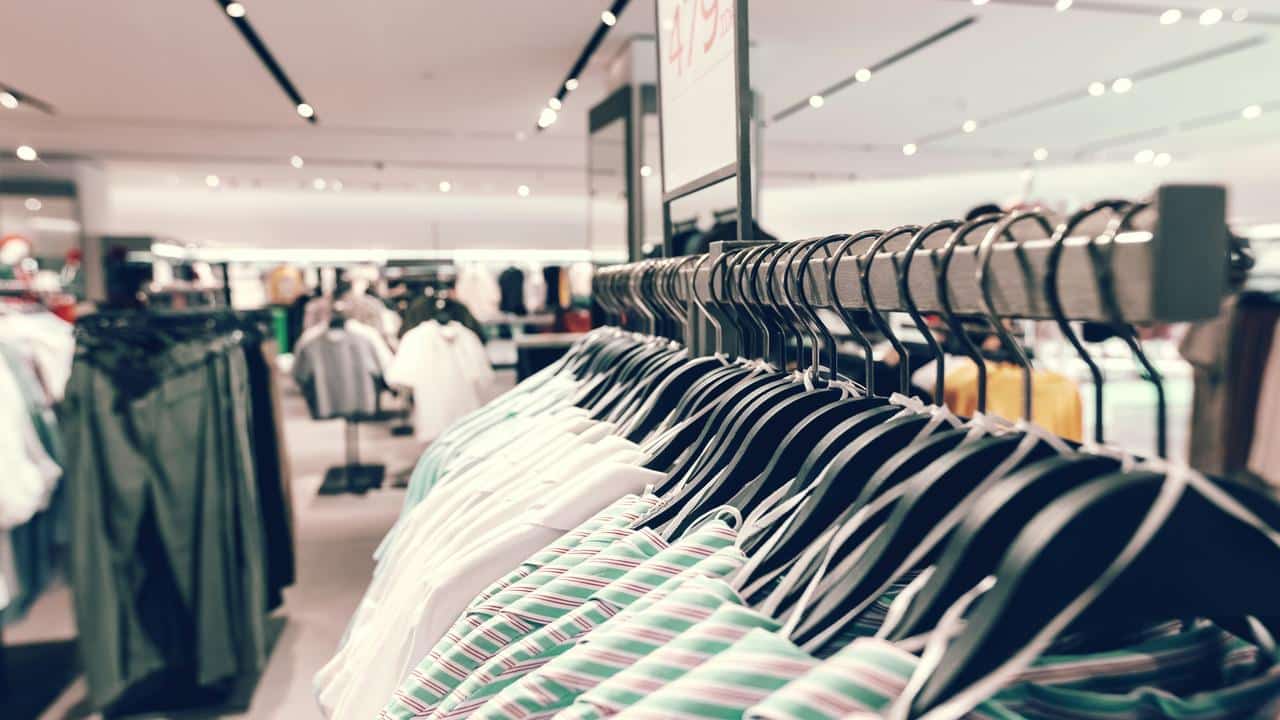 A clothing rack with shirts on hangers in a store.