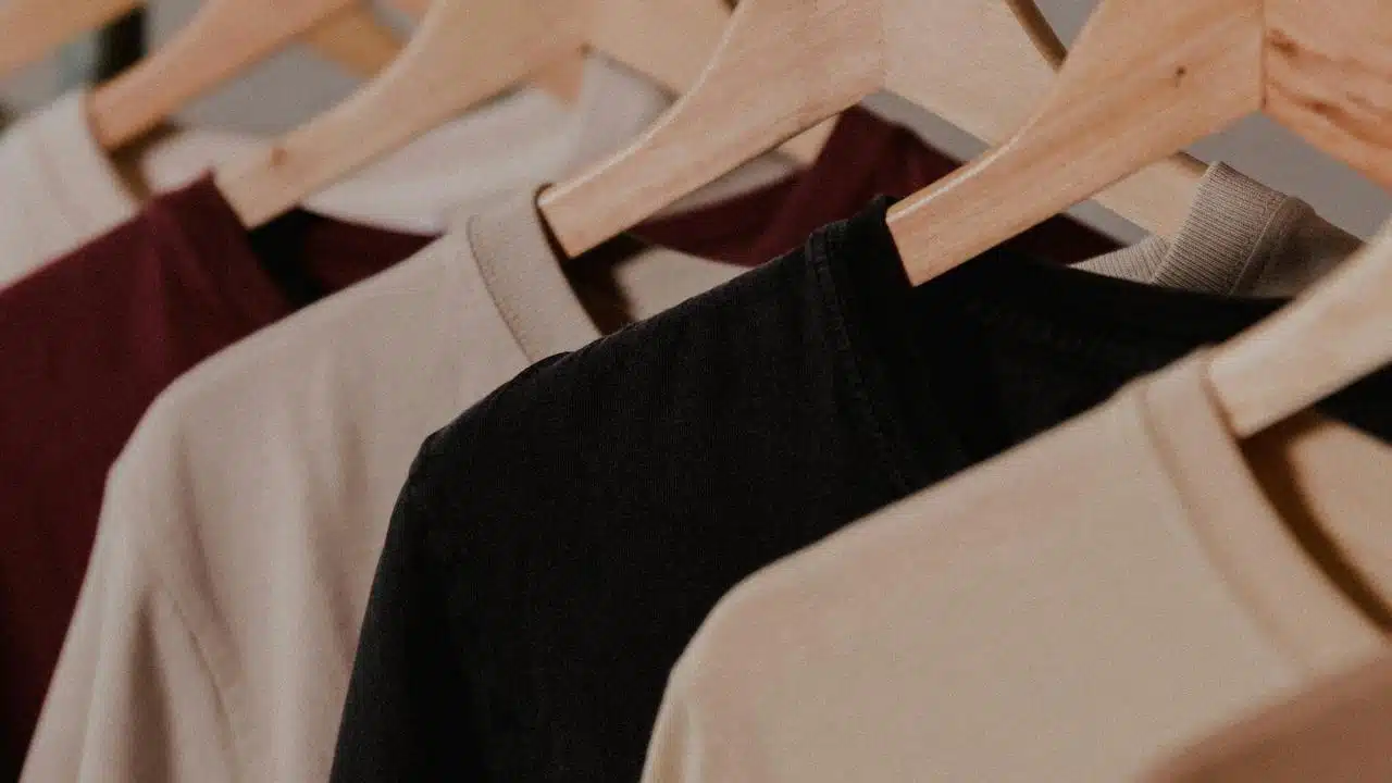 A close-up of shirts on wooden hangers.