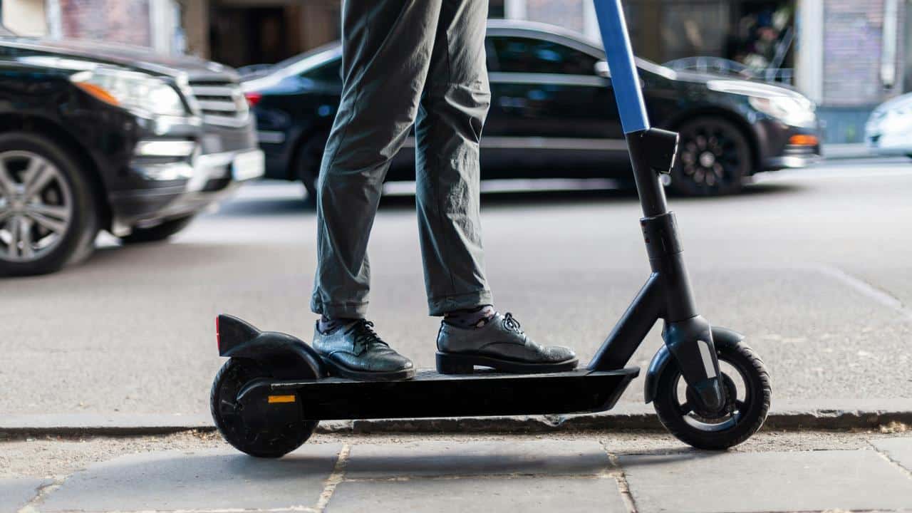 A person riding an electric scooter on a city street.