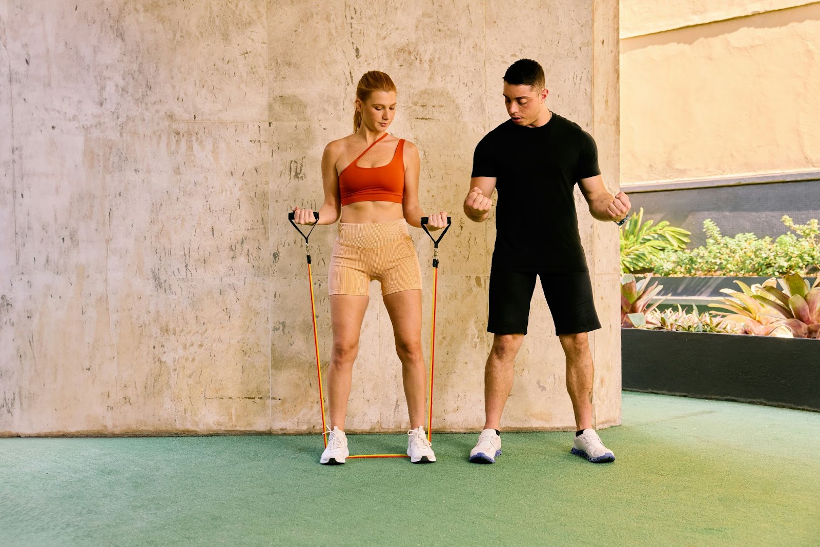 A man guiding a woman how to do the exercise properly.