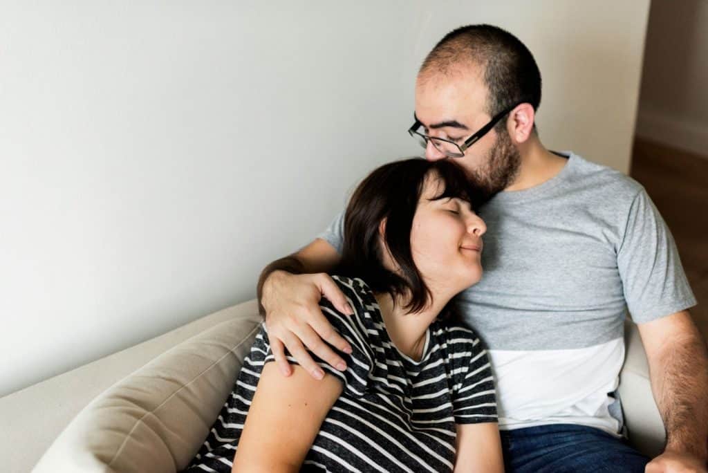 A man kissing a woman’s forehead