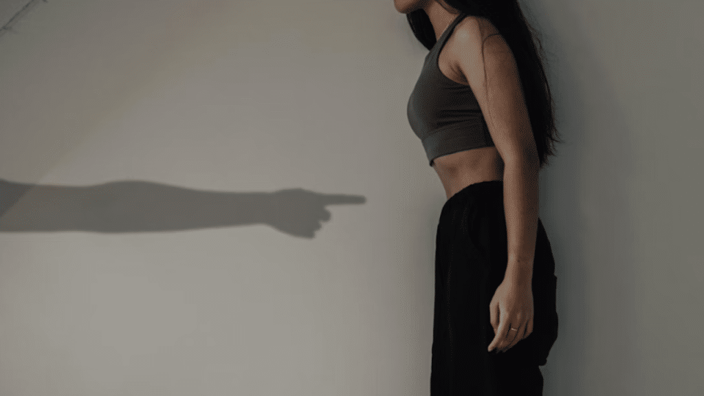 A man’s hand pointing at a woman’s stomach.