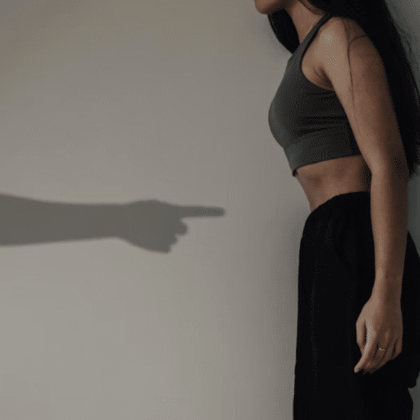 A man’s hand pointing at a woman’s stomach.
