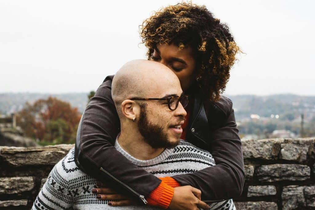 A woman kissing a man’s head