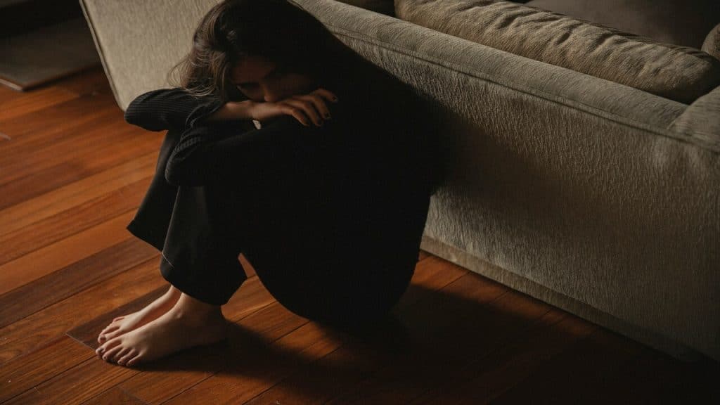 A sad woman behind the couch