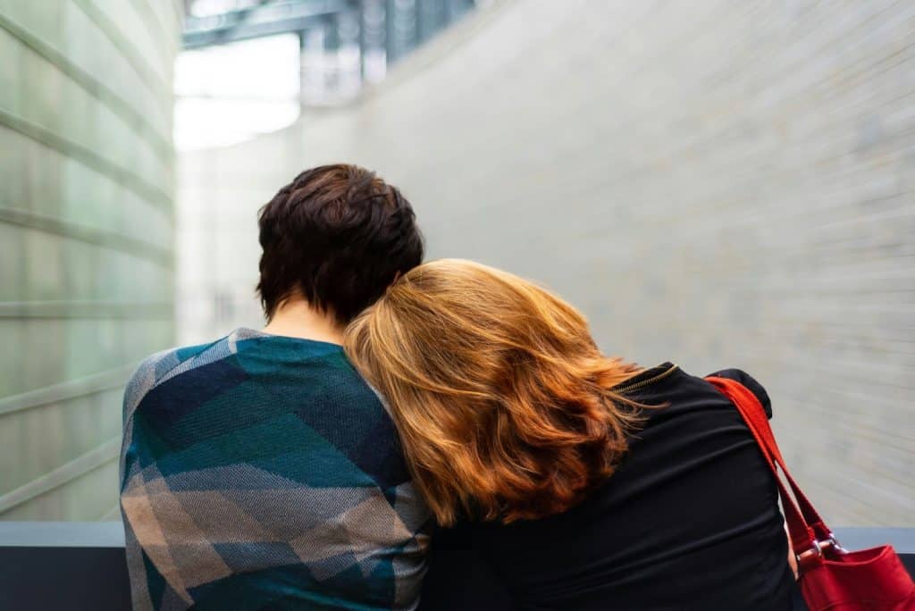 A woman resting her head to a man’s shoulder.