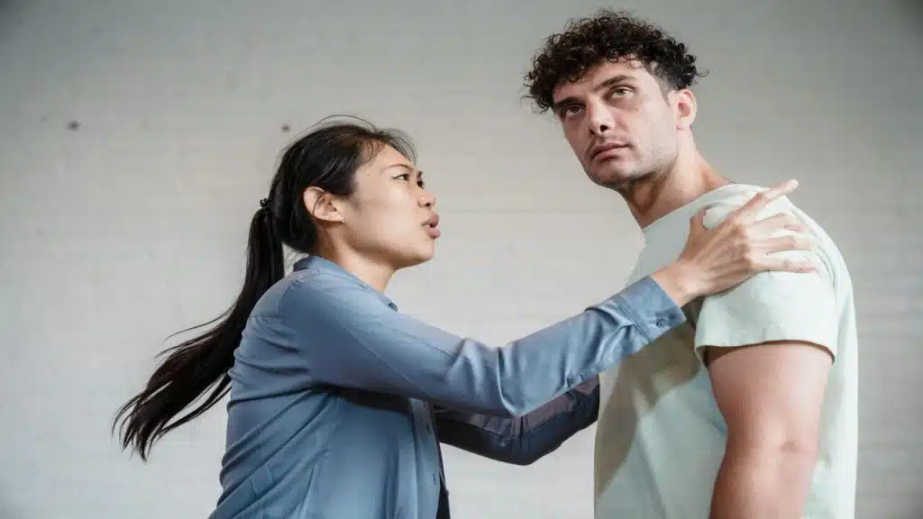 A wife trying to shake her husband to look at her