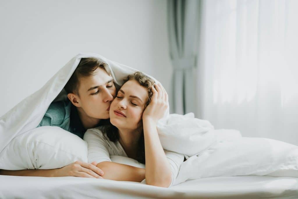 A man and woman at the bed.
