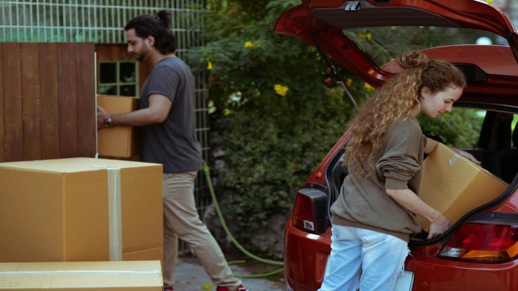 A couple moving their boxes to the car.