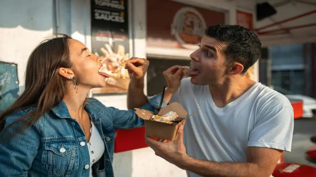 A couple feeding each other food.