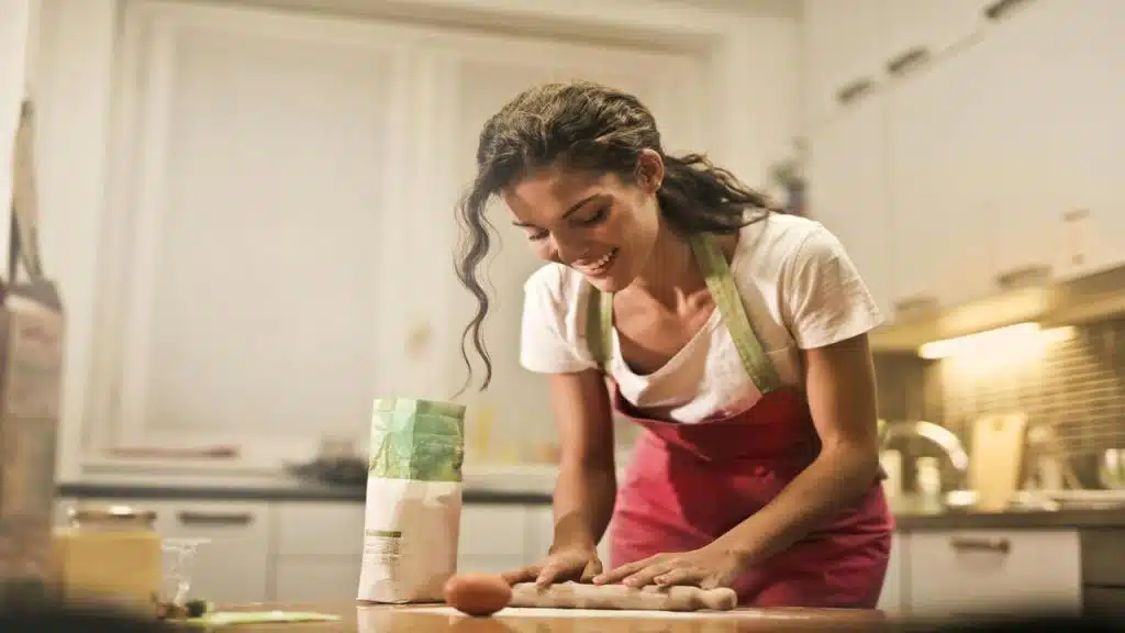 A woman cooking while smiling.