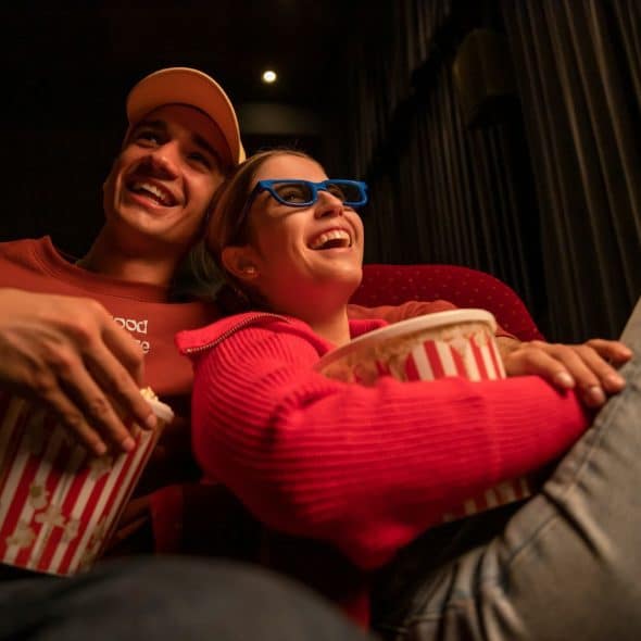 A man and woman watching a movie.