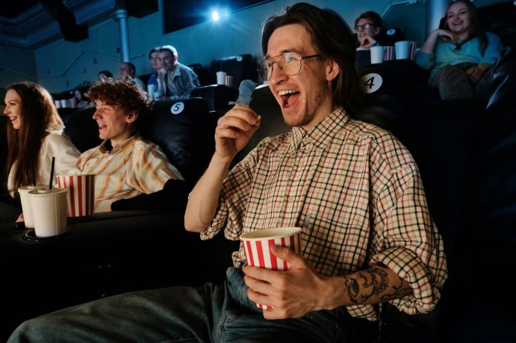 A man watching movie while eating popcorn.