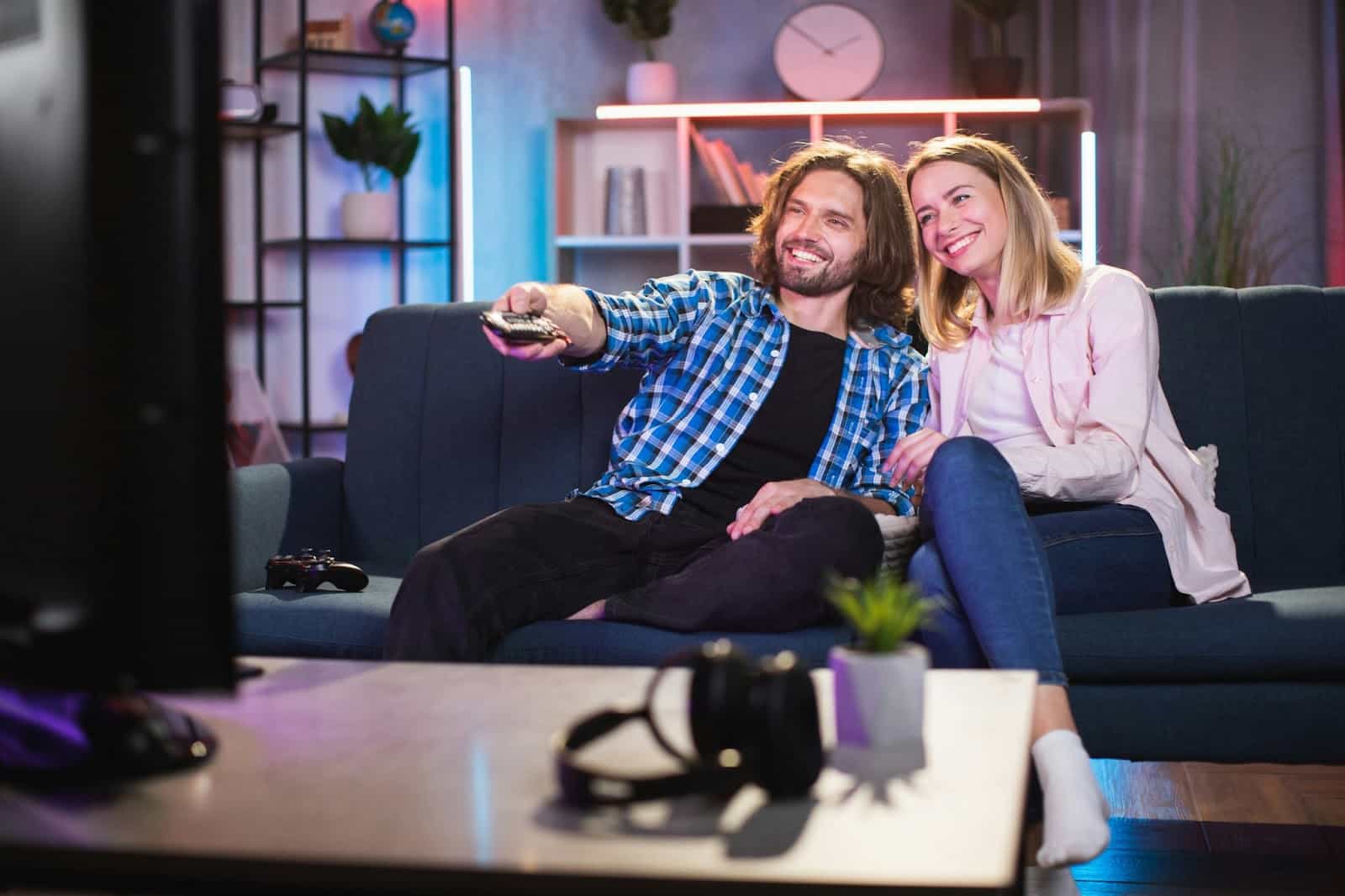 A man and woman watching a tv.