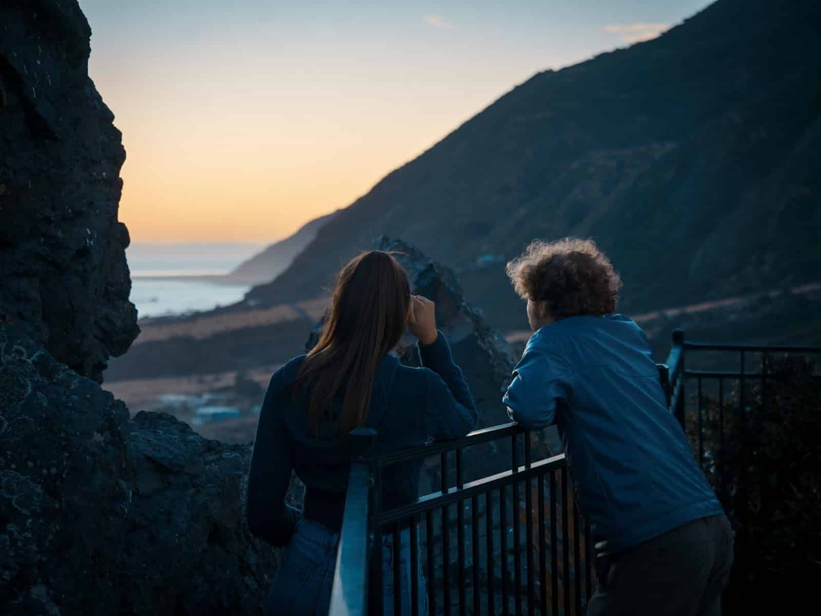 A man and woman watching a sunset together.