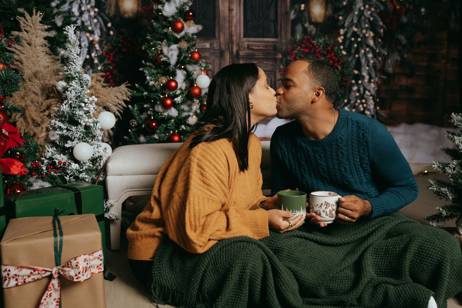A man and woman drinking hot cocoa during christmas.