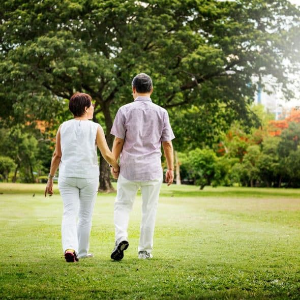 A man and woman holding hands at the park.