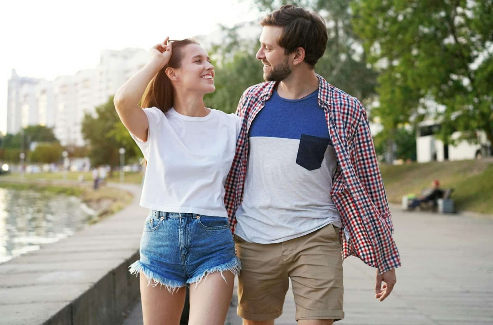A man and woman walking outside while talking.