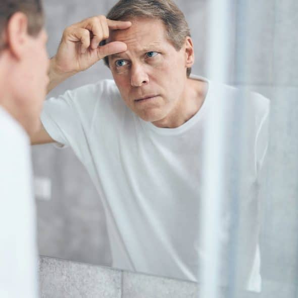 A man looking at the mirror.